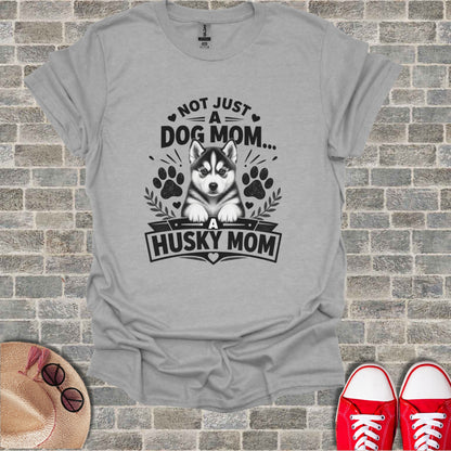 Grey t-shirt with black text and husky graphic. "Not Just A Dog Mom... A Husky Mom".