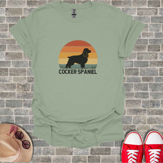 Green t-shirt with a retro Cocker Spaniel sunset graphic and text.