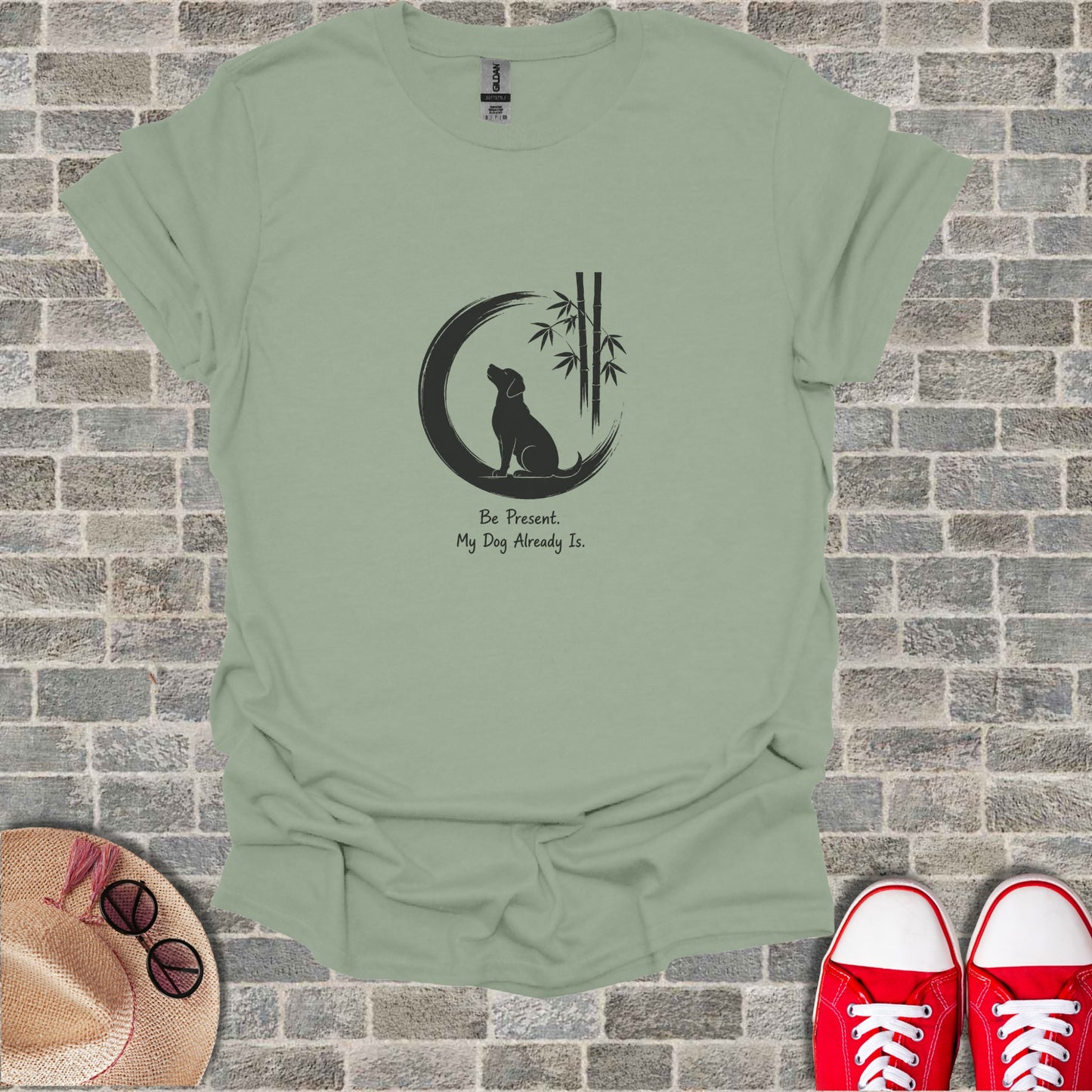 Sage green t-shirt with a black silhouette of a dog sitting under a crescent moon and bamboo.