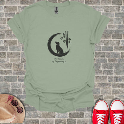 Sage green t-shirt with a black silhouette of a dog sitting under a crescent moon and bamboo.