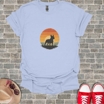 French bulldog silhouette against a sunset on a light blue t-shirt.