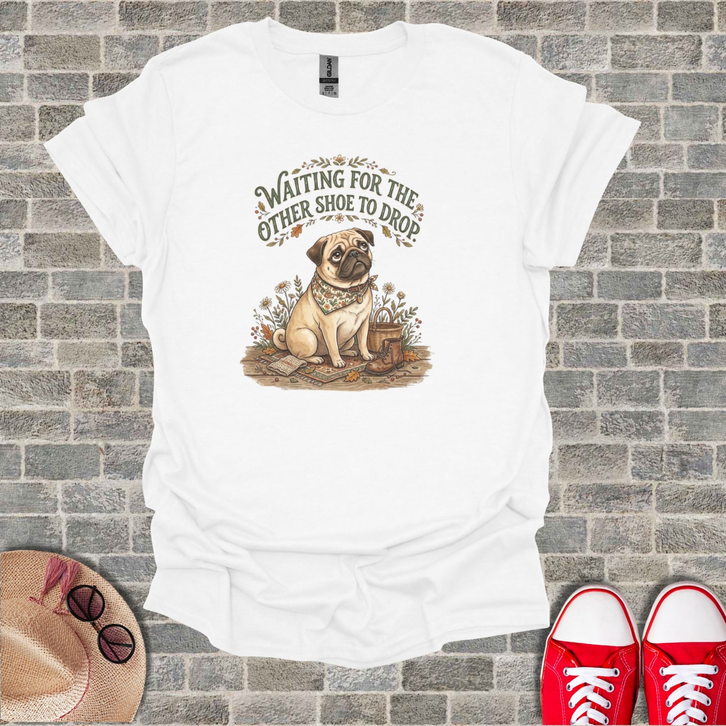 Pug wearing bandana, sitting with boots and flowers, text "Waiting for the other shoe to drop".