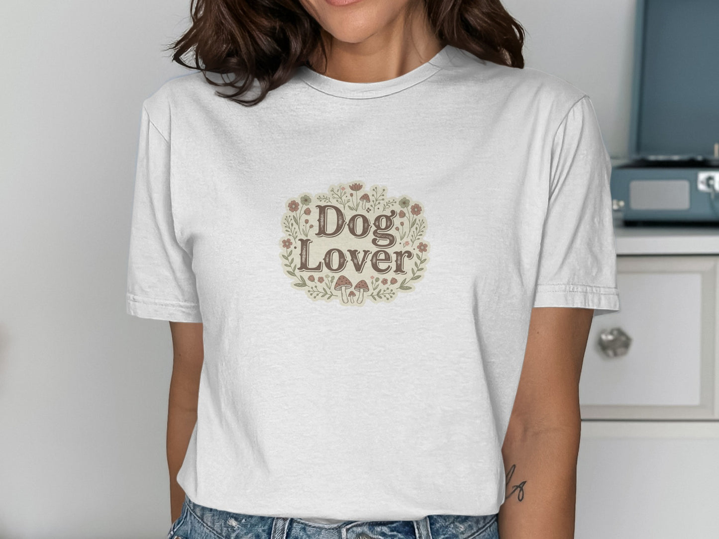 White t-shirt with "Dog Lover" text surrounded by flowers and mushrooms.