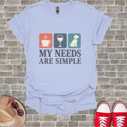 Light blue t-shirt with coffee cup, wine glass, dog icons and text "MY NEEDS ARE SIMPLE".