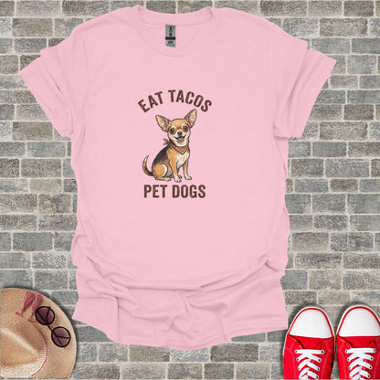 Pink t-shirt with chihuahua wearing bandana, "EAT TACOS PET DOGS" text.