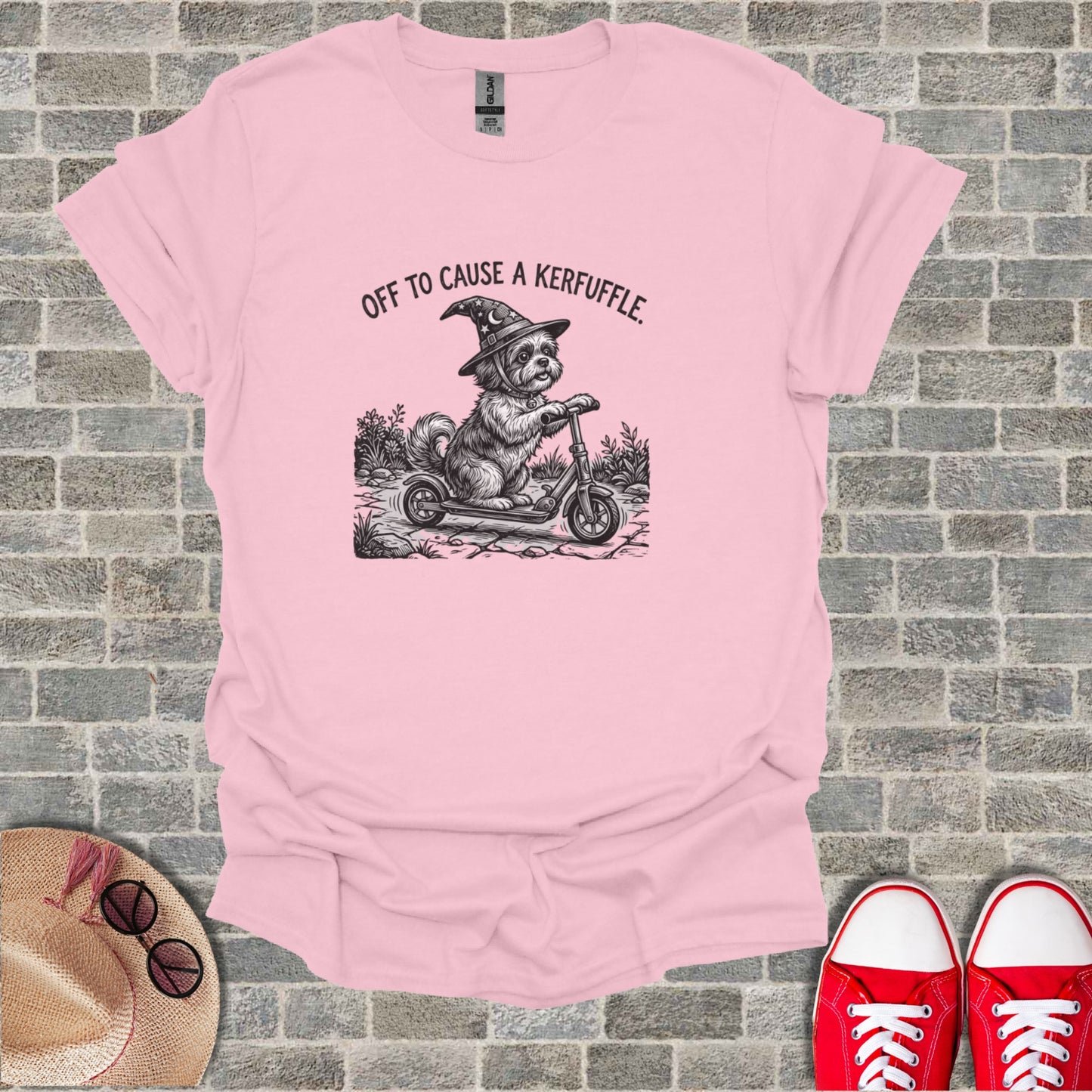 Dog wearing witch hat riding a scooter, "OFF TO CAUSE A KERFUFFLE."