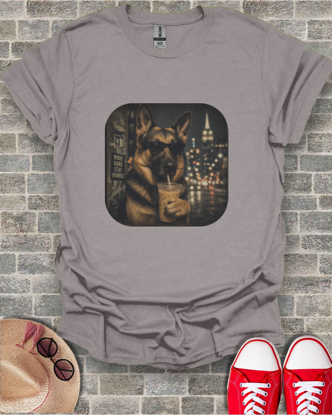 German Shepherd wearing sunglasses drinks iced coffee in front of city lights.