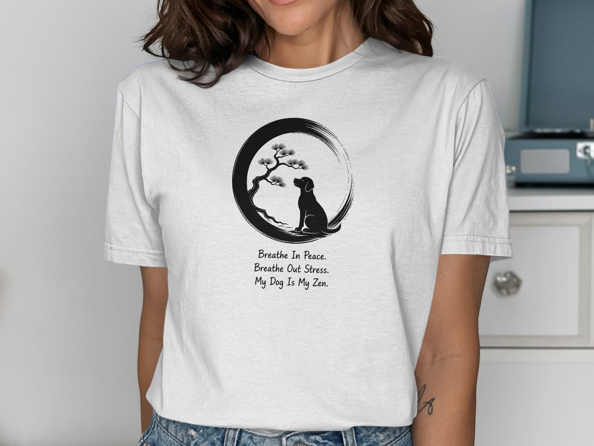 Woman wearing a t-shirt with a dog meditating under a tree, with text.