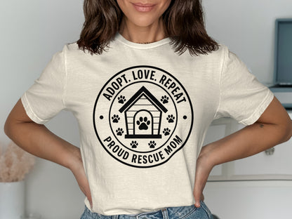 Cream t-shirt with "Adopt. Love. Repeat. Proud Rescue Mom" text and paw print design.
