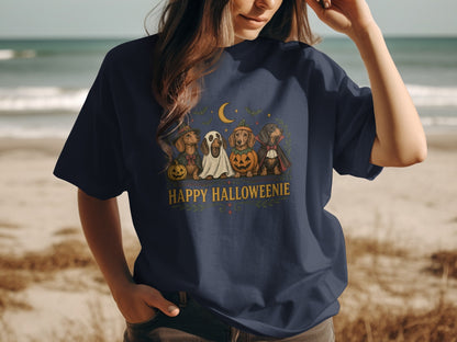 Dachshunds in Halloween costumes under a moon with text "Happy Halloweenie".
