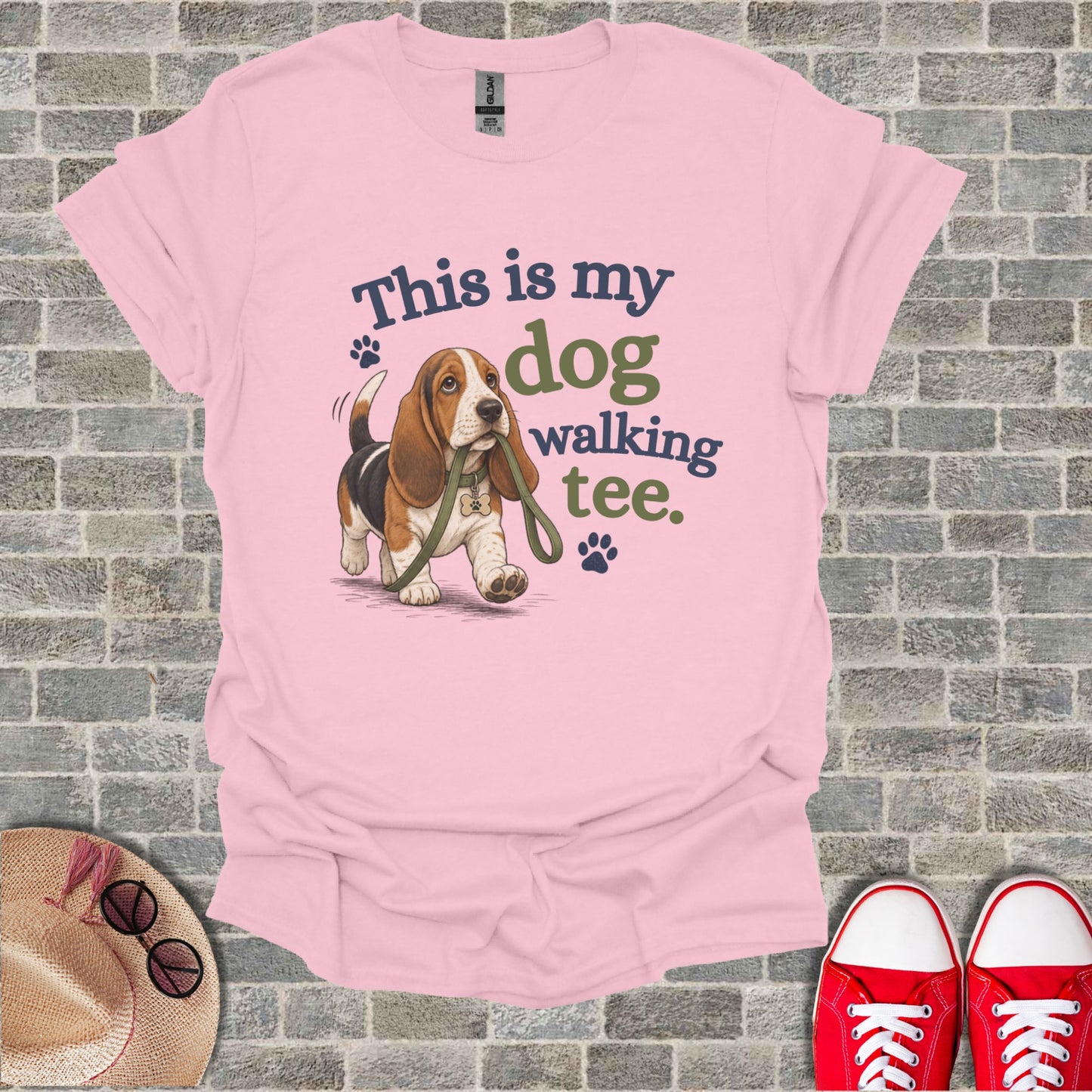 Basset hound on leash with "This is my dog walking tee" text.