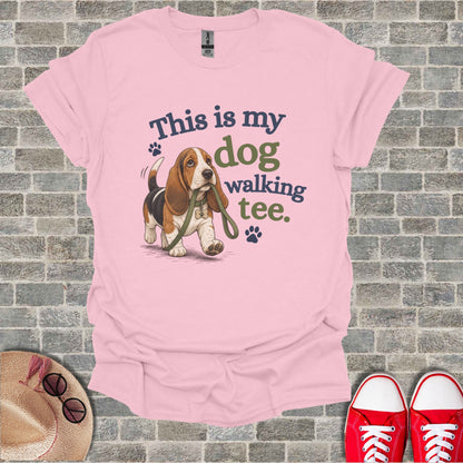 Basset hound on leash with "This is my dog walking tee" text.
