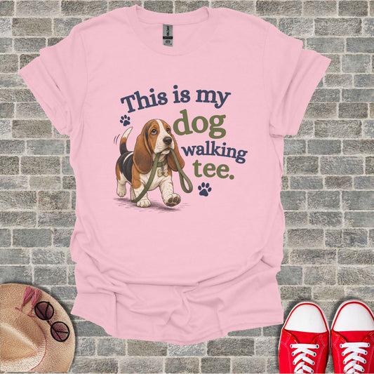 Basset hound on leash with "This is my dog walking tee" text.