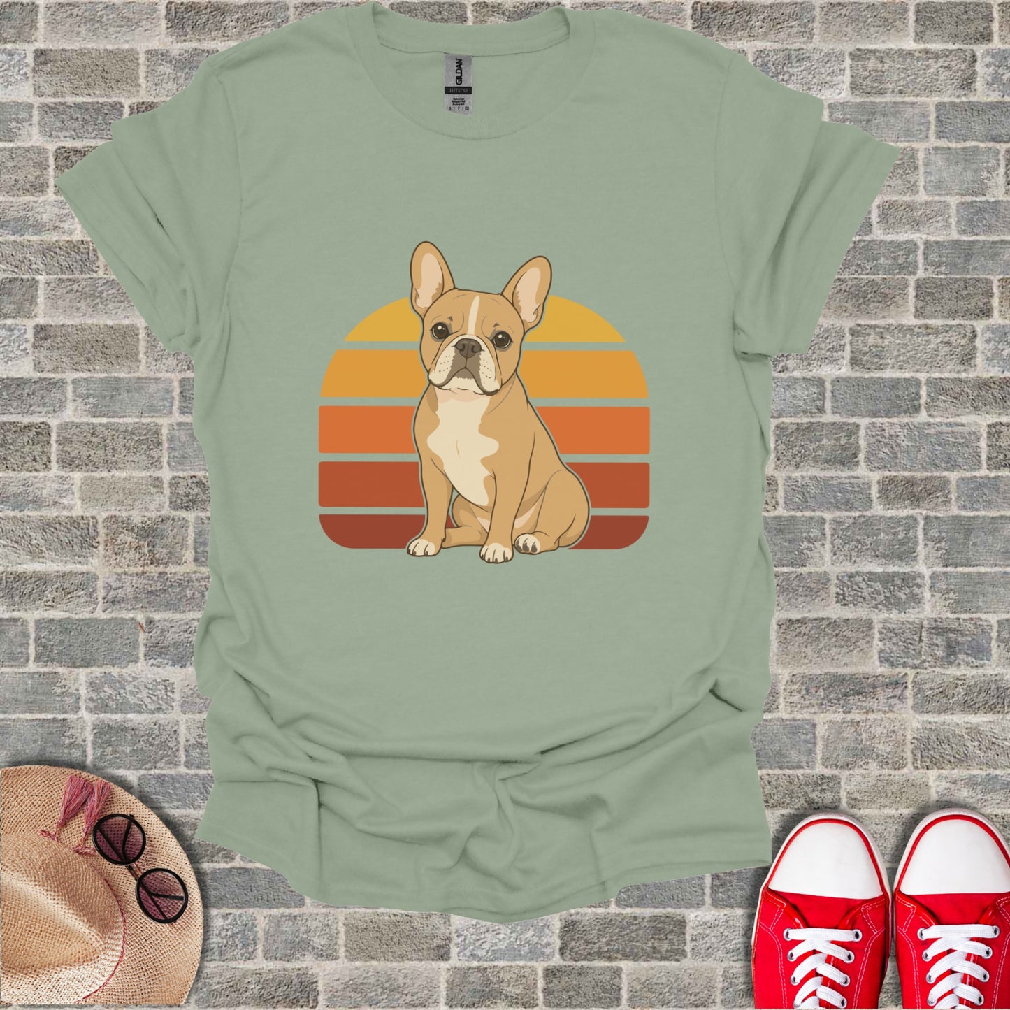 French bulldog sitting in front of a sunset with orange and yellow stripes.