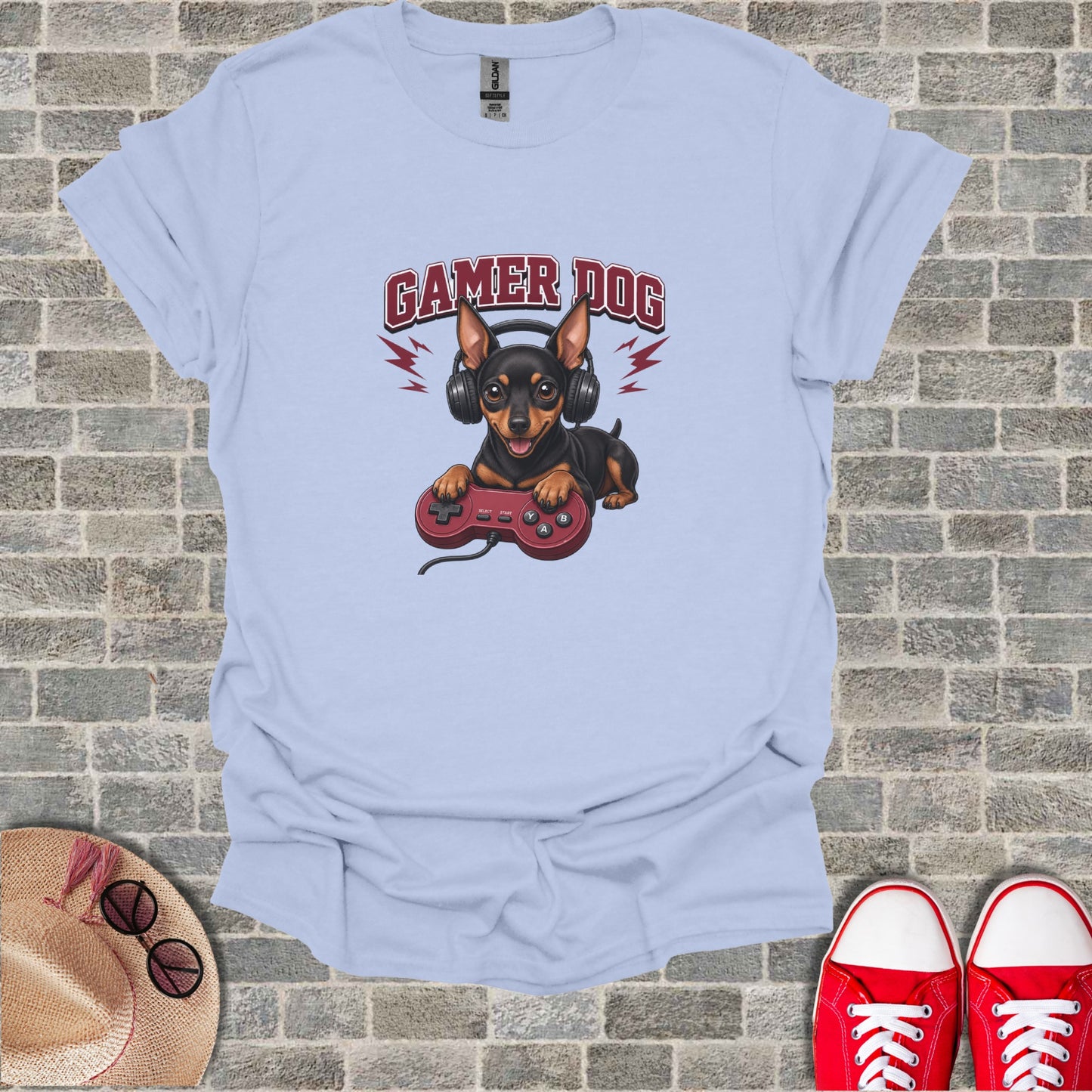 Light blue t-shirt with cartoon dog wearing headphones and holding a video game controller.