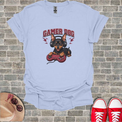 Light blue t-shirt with cartoon dog wearing headphones and holding a video game controller.