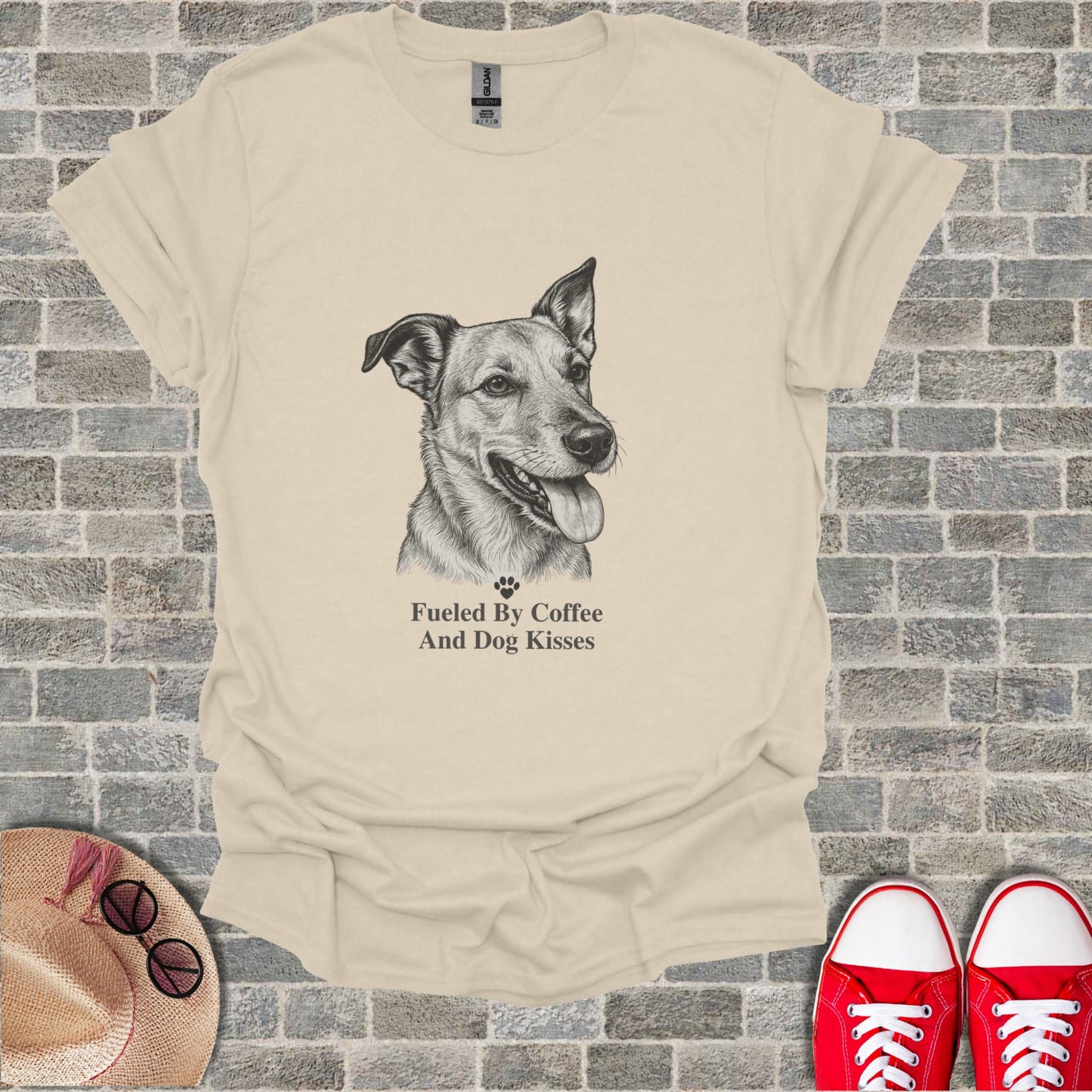 Beige t-shirt with line drawing of a dog and text "Fueled By Coffee And Dog Kisses".