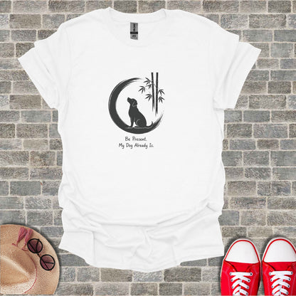 White t-shirt with a dog, moon, bamboo, and text "Be Present. My Dog Already Is."