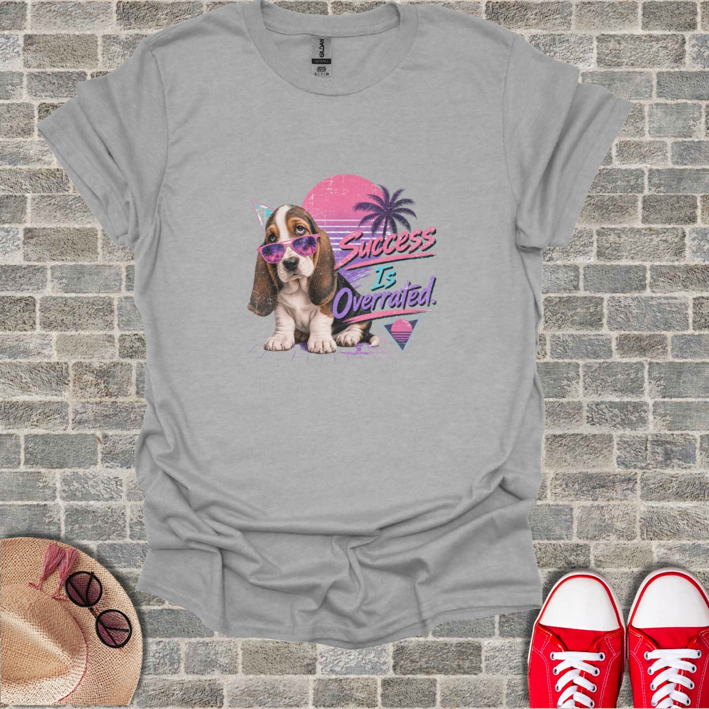 Basset hound wearing sunglasses and a graphic that reads "Success Is Overrated".