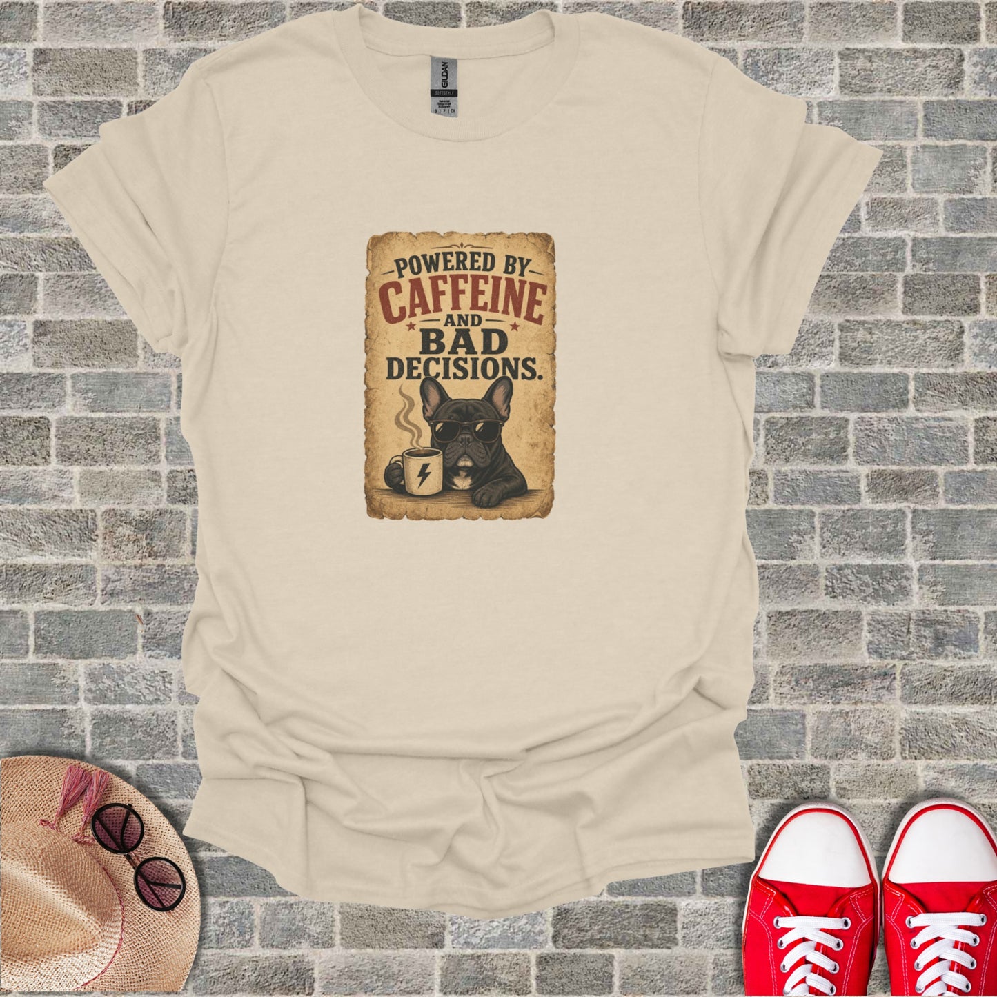 French bulldog wearing sunglasses holding coffee mug with "Powered by Caffeine and Bad Decisions" text.