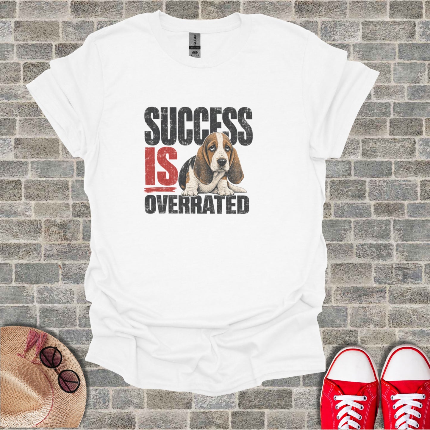 White t-shirt with "SUCCESS IS OVERRATED" text and a sad basset hound illustration.