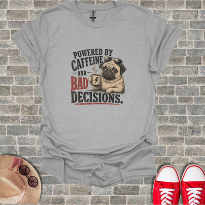 Gray t-shirt with pug wearing sunglasses holding coffee cup, text "POWERED BY CAFFEINE AND BAD DECISIONS."