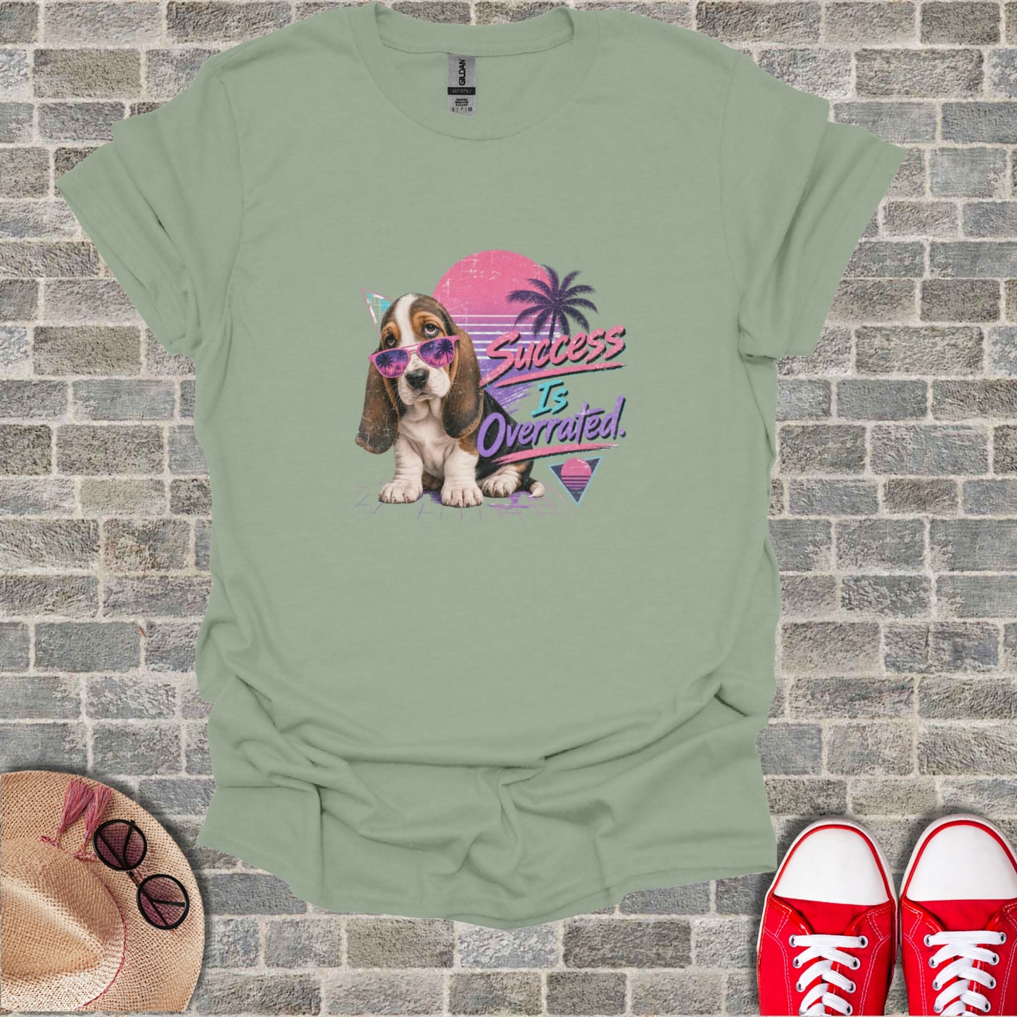 Basset hound puppy with sunglasses and a party hat, text "Success is Overrated".