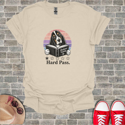 Cream t-shirt with graphic of a basset hound reading a book titled "Obedience Training" and "Hard Pass."