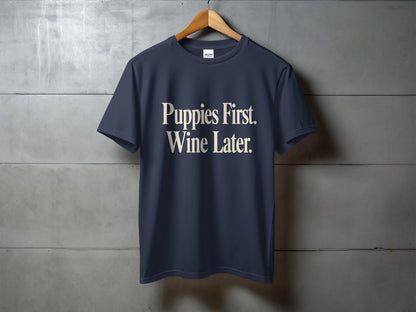 Navy t-shirt with white text "Puppies First. Wine Later."