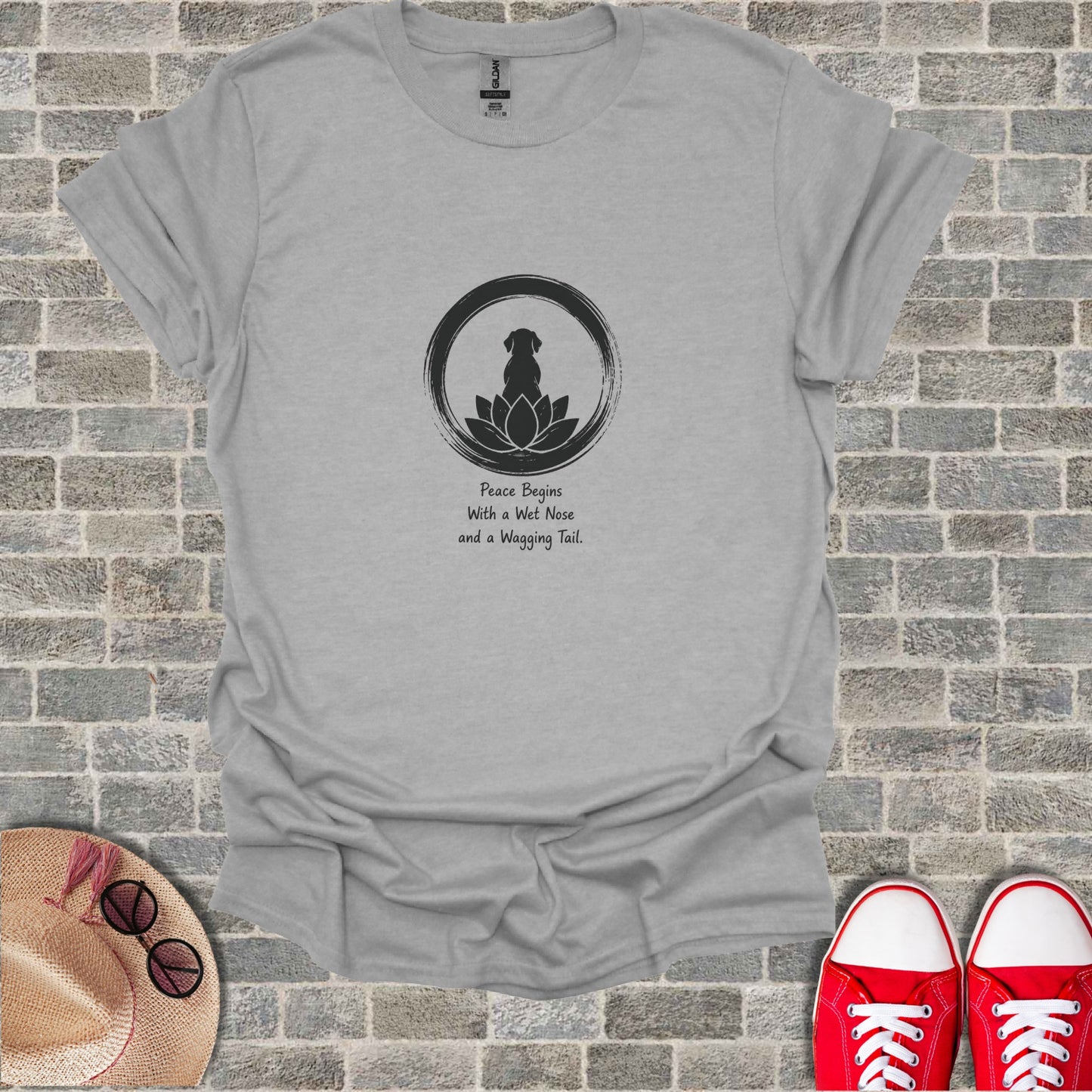 Gray t-shirt with a black silhouette of a dog inside a circle with lotus petals, text reads "Peace Begins With a Wet Nose and a Wagging Tail."