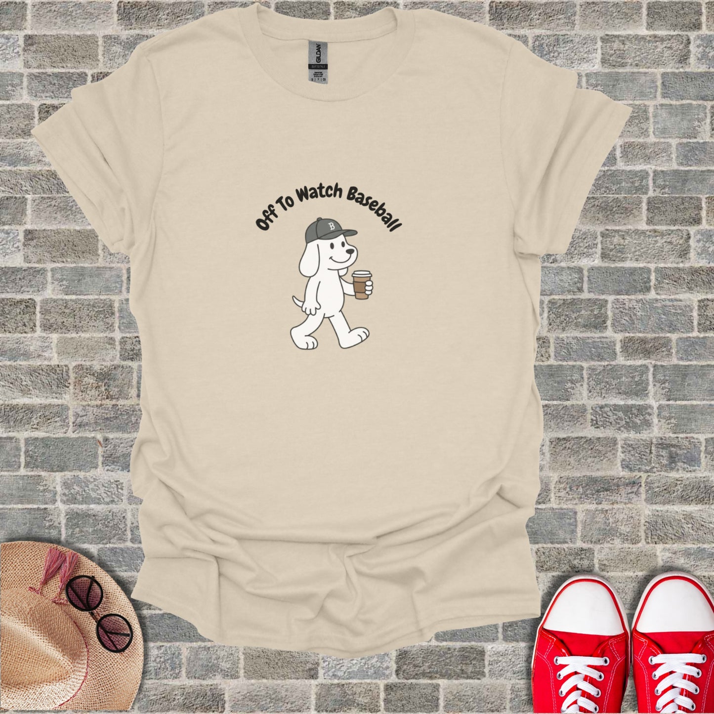 White dog with "Off To Watch Baseball" text, holding coffee cup.