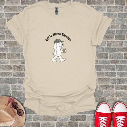 White dog with "Off To Watch Baseball" text, holding coffee cup.