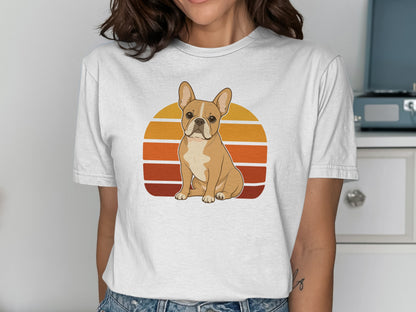 French bulldog sitting in front of a retro sunset graphic on a white t-shirt.