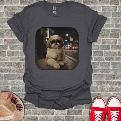 Shih Tzu dog wearing sunglasses drinks iced coffee on a city street at night.
