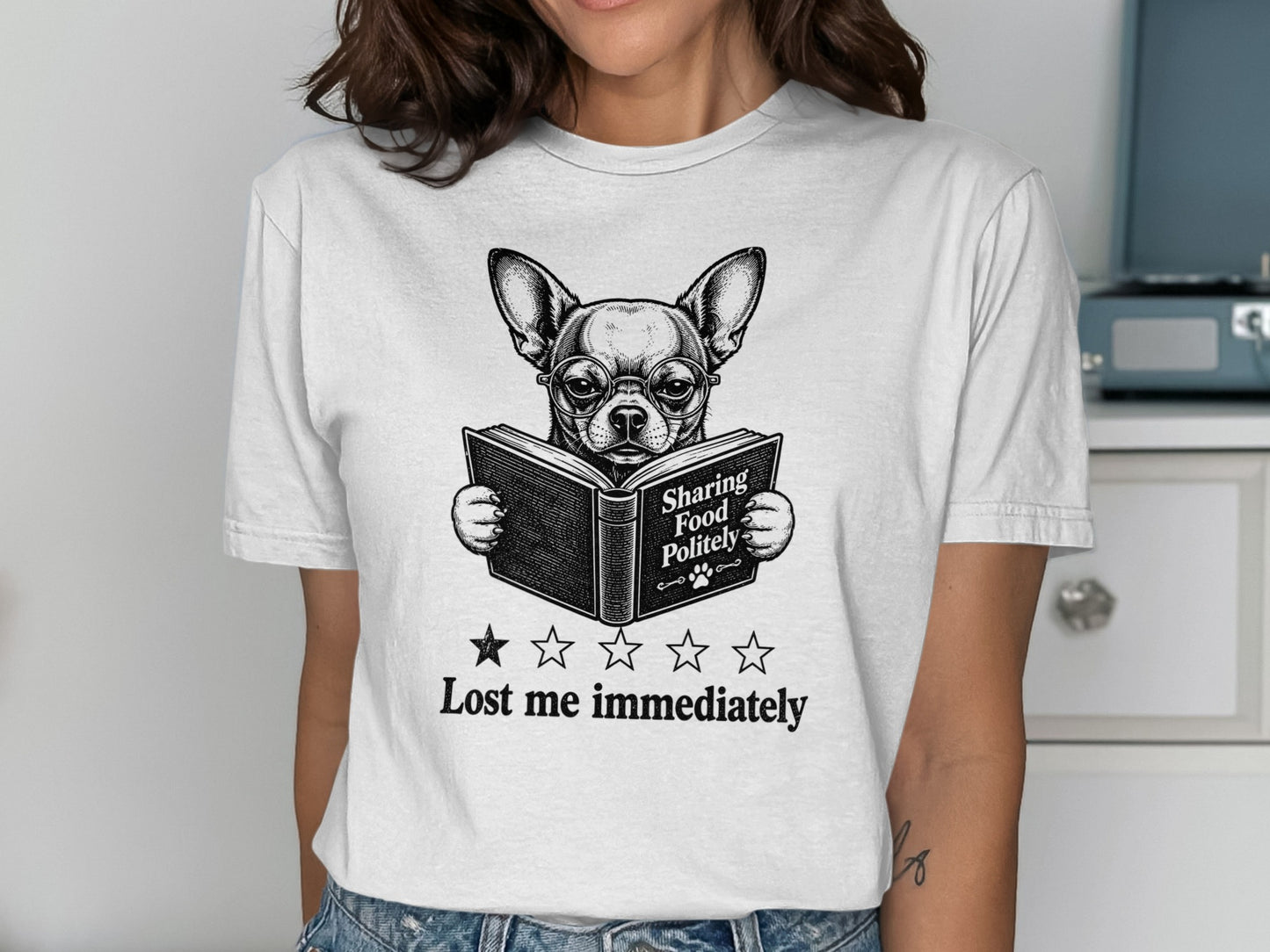 T-shirt graphic of a chihuahua wearing glasses reading a book, "Sharing Food Politely."