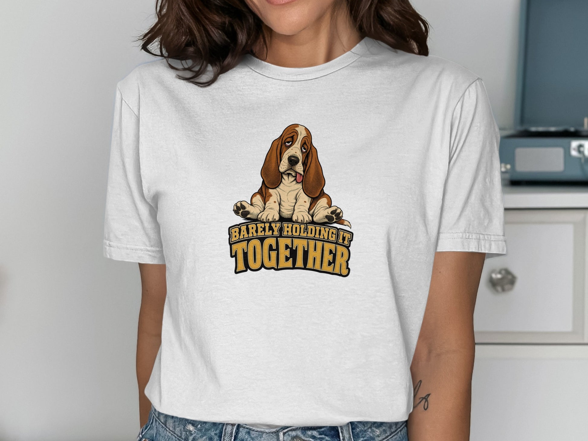 Basset hound graphic with text "barely holding it together" on a white t-shirt.