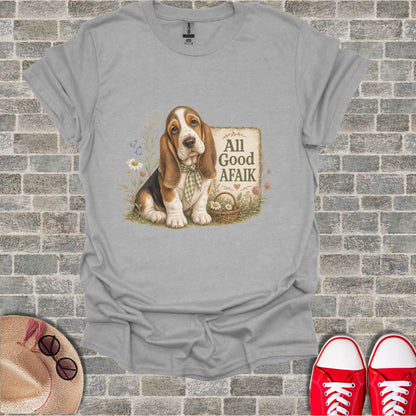 Basset hound with bandana sits beside a basket of flowers, text "All Good Afaik".