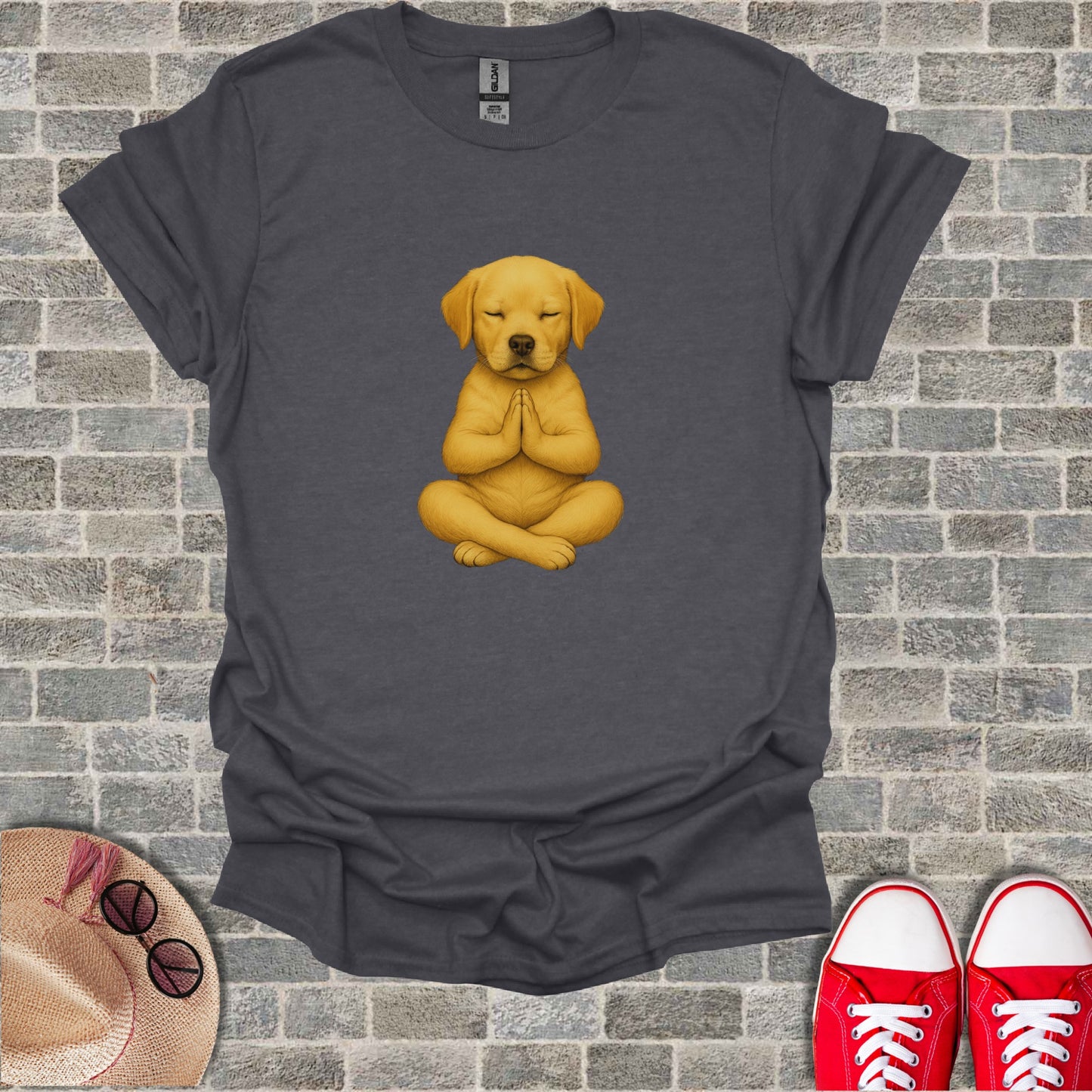 Yellow lab puppy meditating in lotus pose on a charcoal t-shirt.