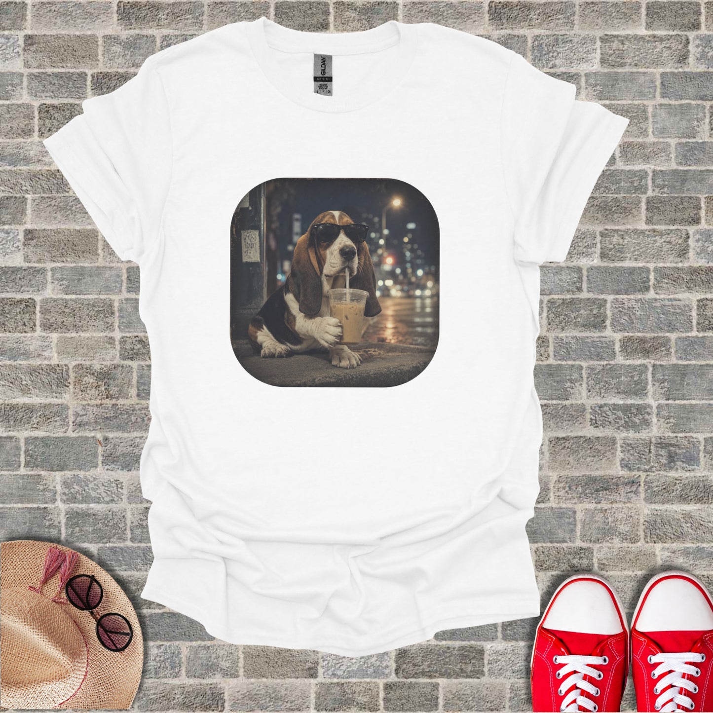 Basset hound wearing sunglasses drinks iced coffee on a street at night.