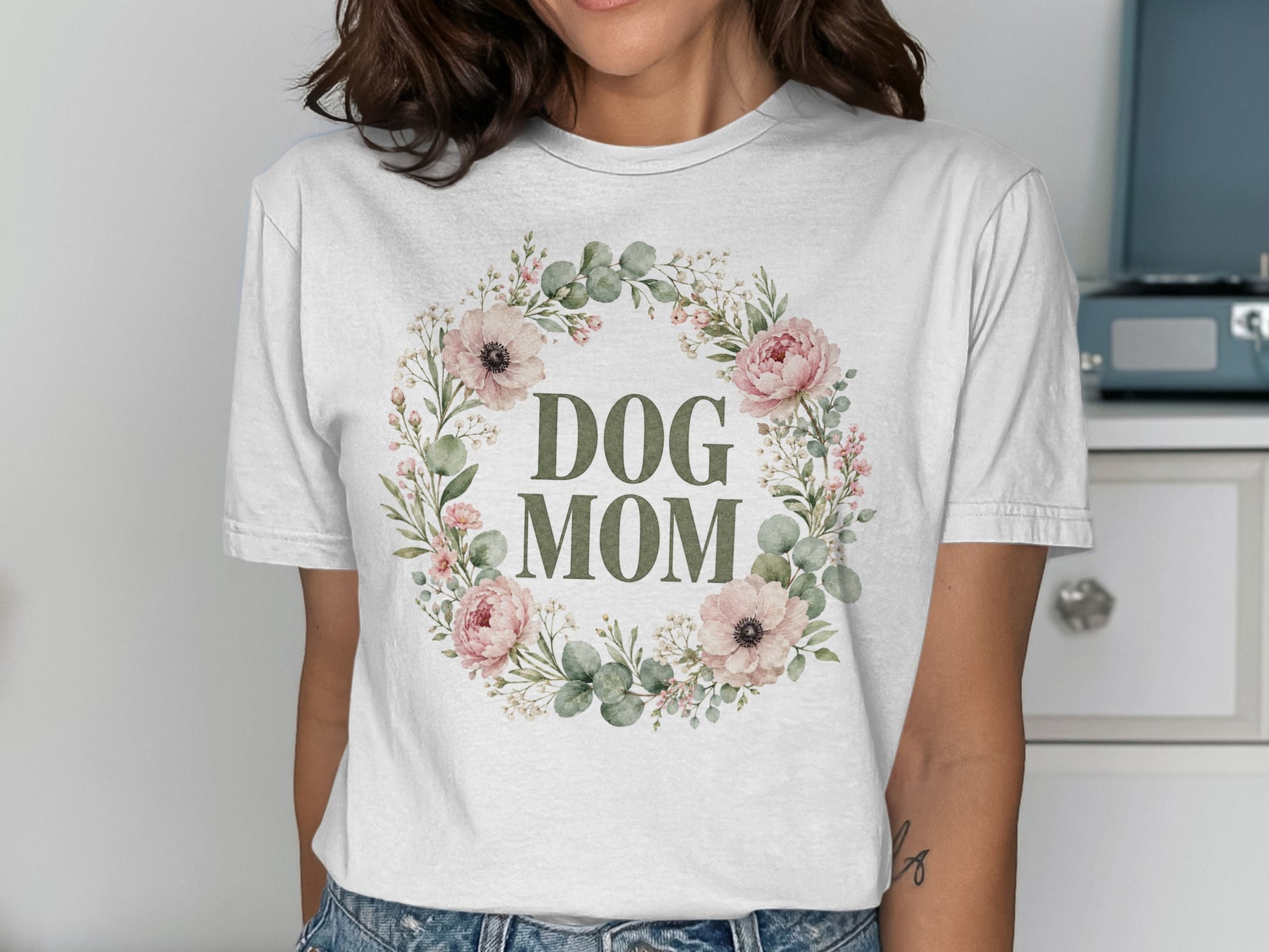 White t-shirt with "DOG MOM" text within a floral wreath design.