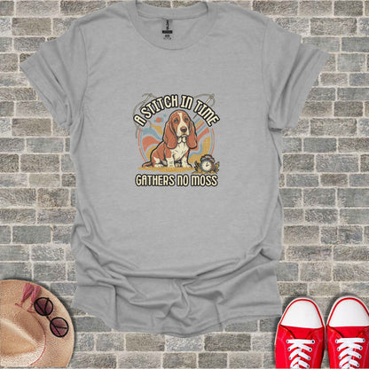 Basset hound wearing a watch and reading a book with "A stitch in time gathers no moss" text.