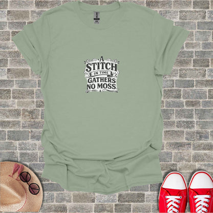 Sage green t-shirt with "A stitch in time gathers no moss" text.