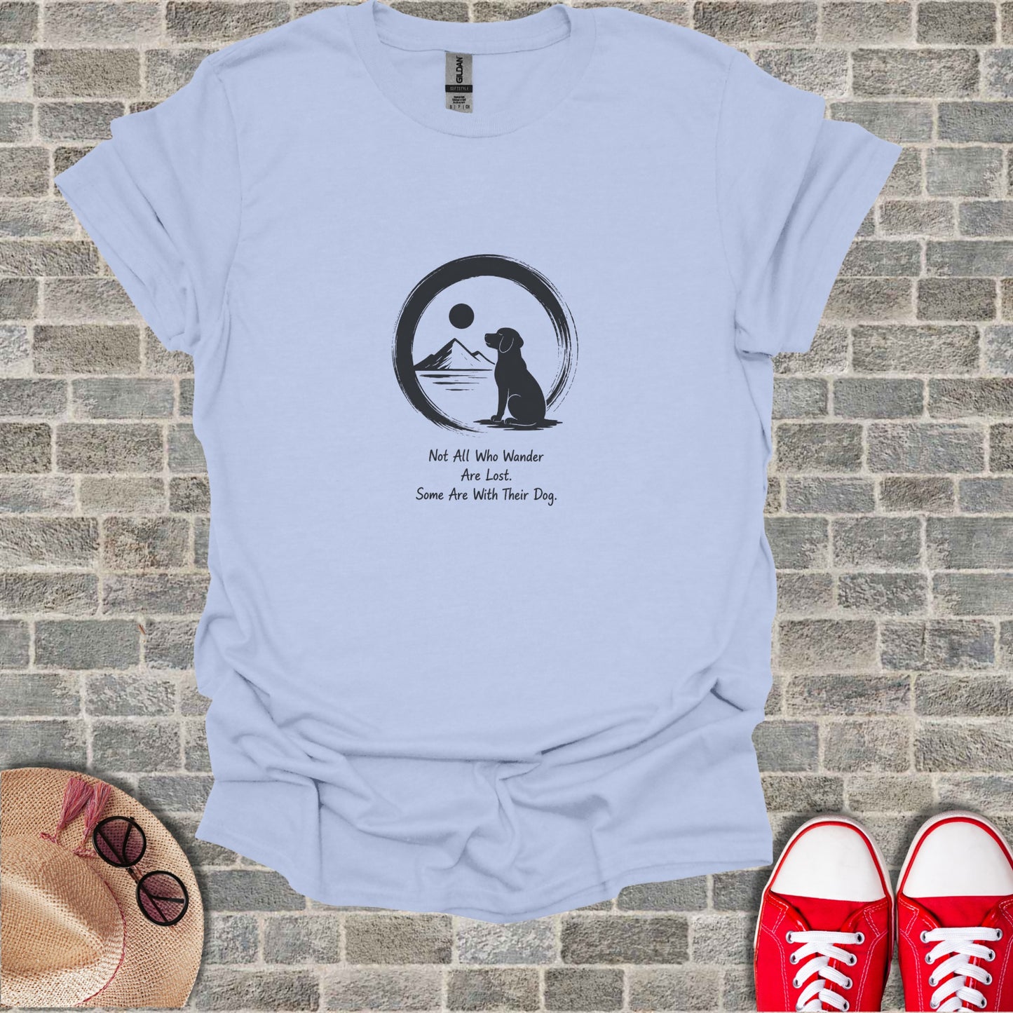 Light blue t-shirt with dog silhouette, moon, sun, and text.