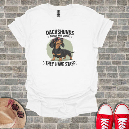Dachshund wearing sunglasses, with text "Dachshunds do not have owners, they have staff".