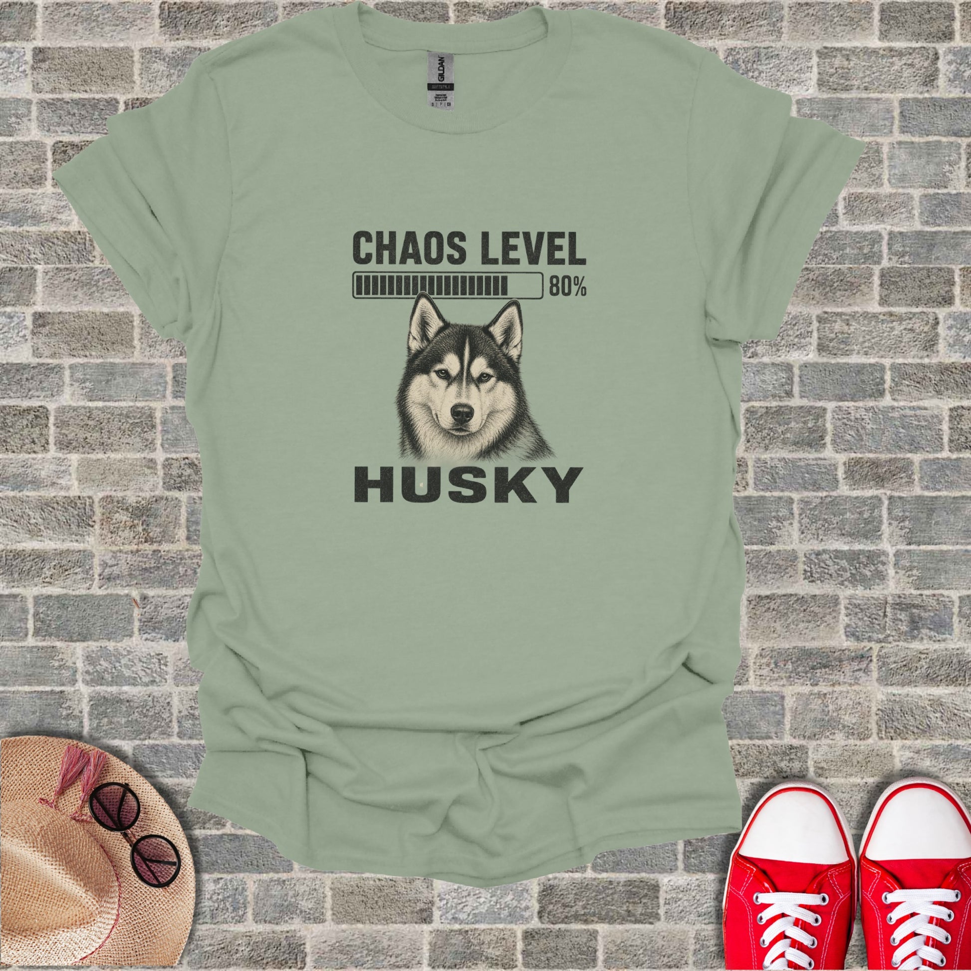Husky dog graphic with "CHAOS LEVEL 80%" text on a sage green t-shirt.