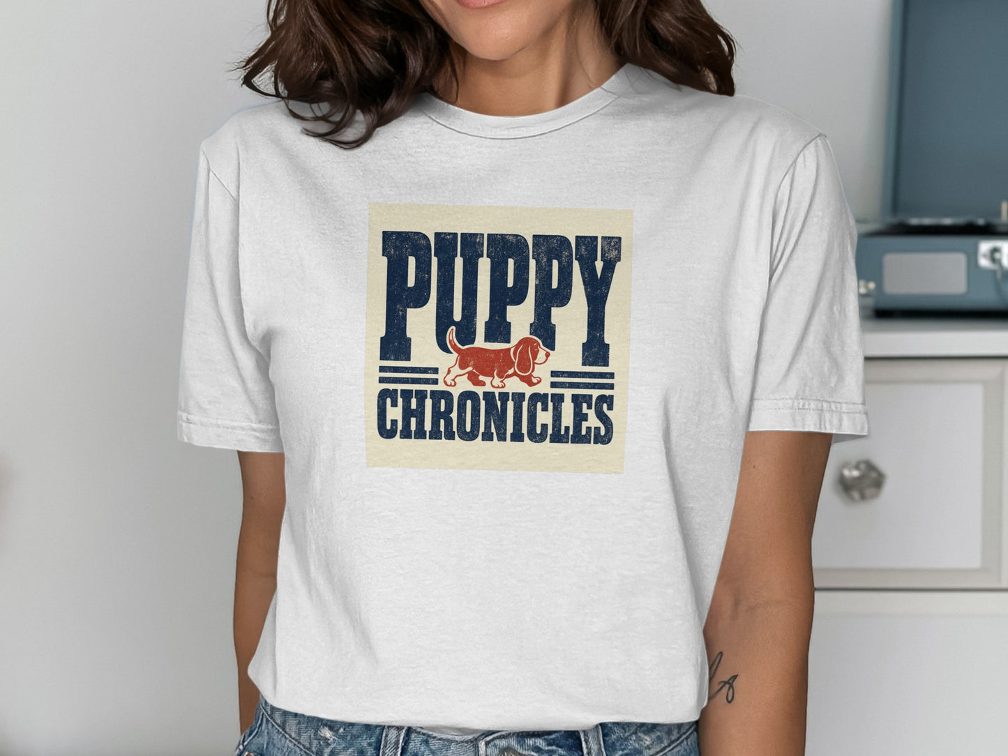 White t-shirt with navy blue "Puppy Chronicles" text and a red basset hound.