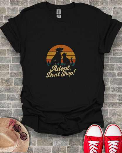 Black t-shirt with "Adopt, Don't Shop!" dog and cat sunset design.