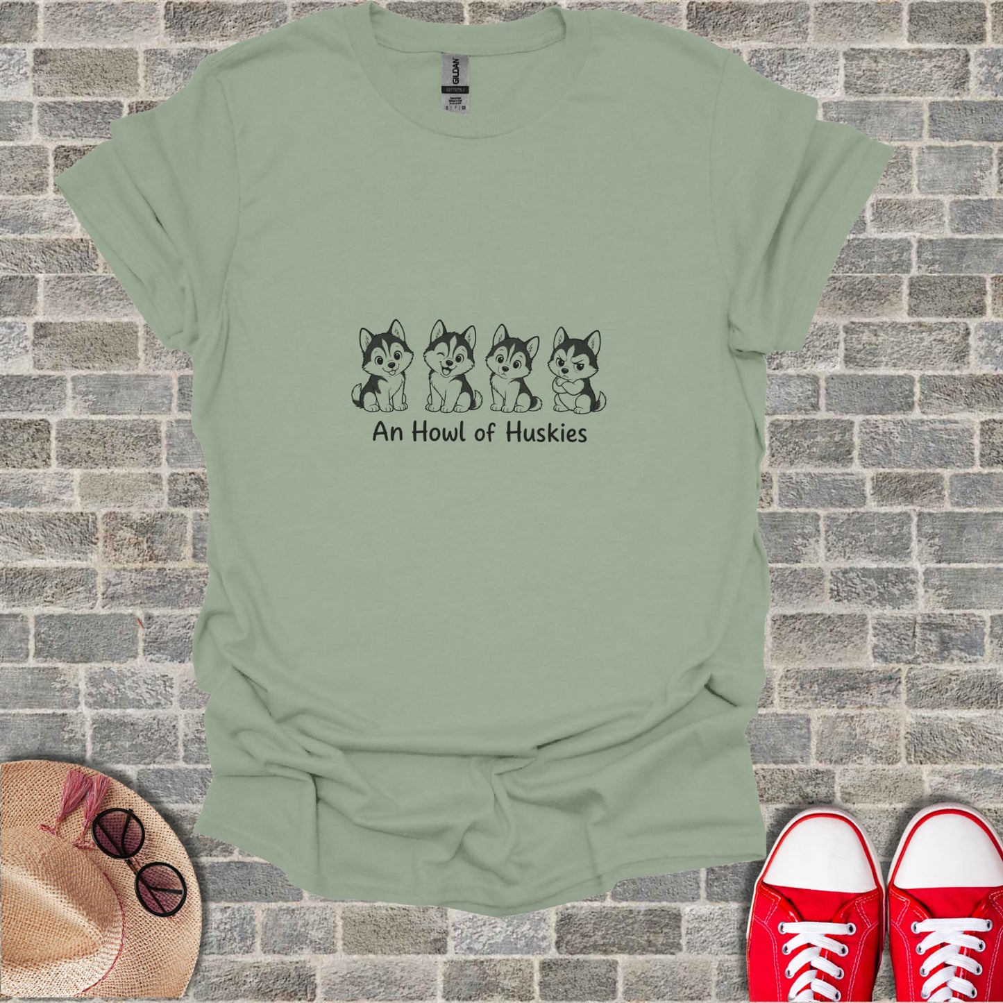 Green t-shirt with line drawing of four husky puppies and text "An Howl of Huskies".
