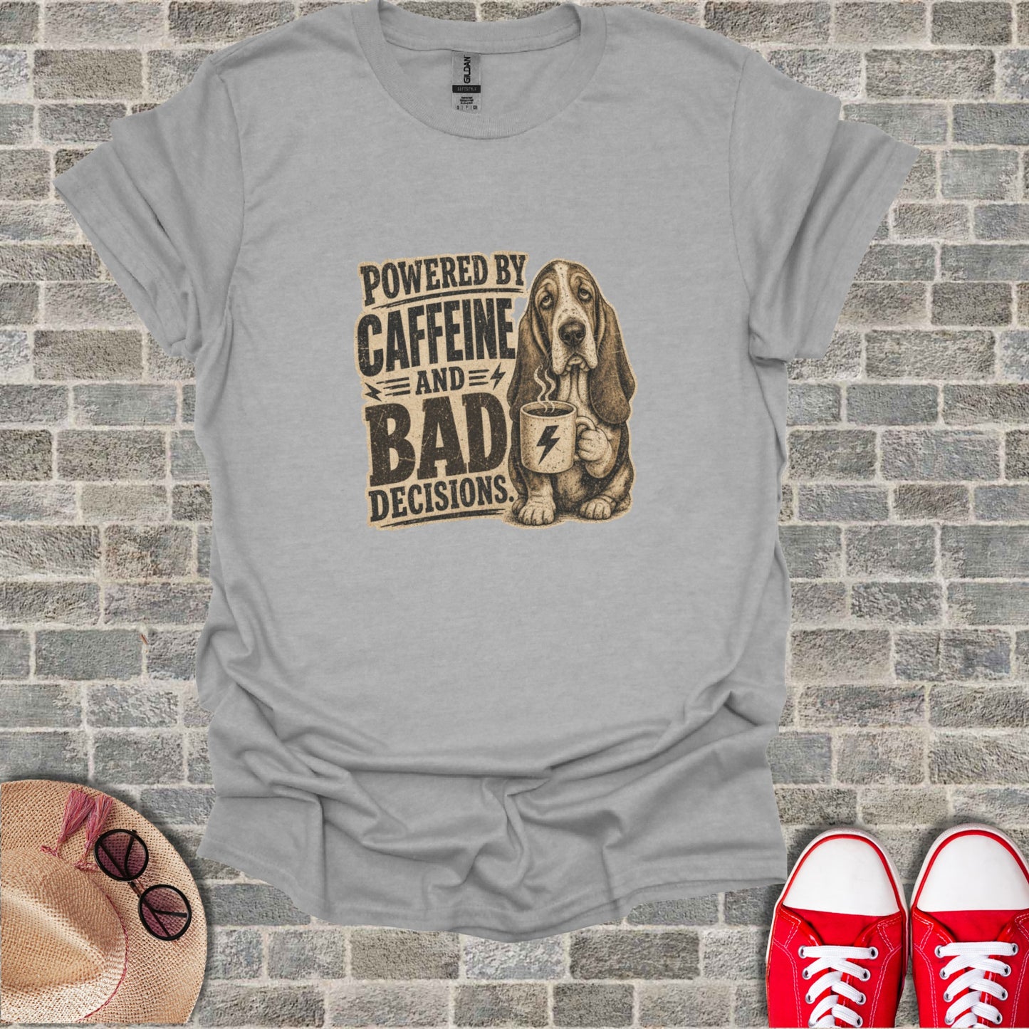 Basset hound wearing a t-shirt that says "Powered by Caffeine and Bad Decisions."