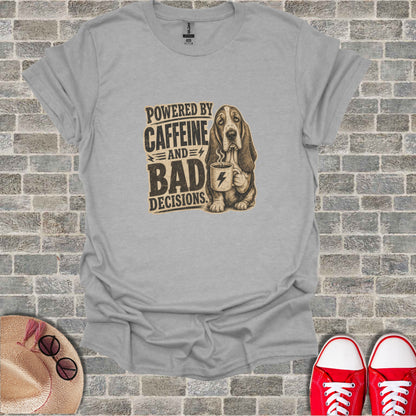 Basset hound wearing a t-shirt that says "Powered by Caffeine and Bad Decisions."